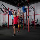 Exerciser shoulder pressing 45LB plates in gym